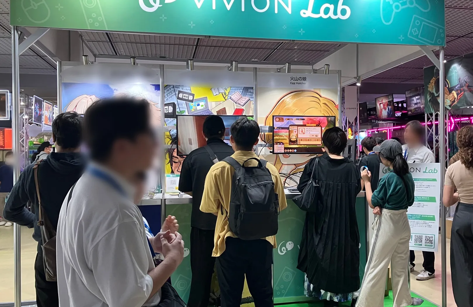 Visitors playing Volcano Princess at a booth, under a panel giving the game's Japanese title and Egg Hatcher as developer.