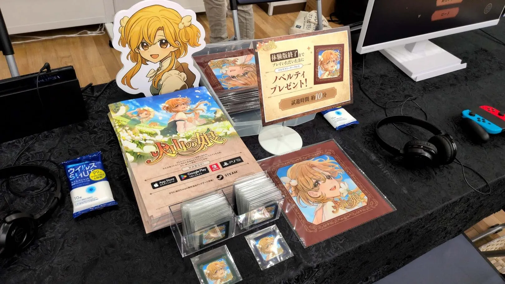 The Volcano Princess table, with two play stations and a large printed banner of the game's key art behind it.